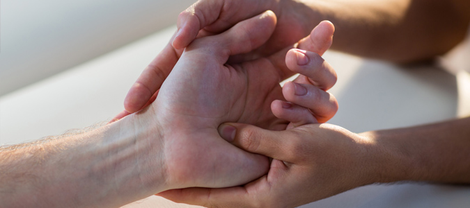 Physiotherapist giving hand massage to patient