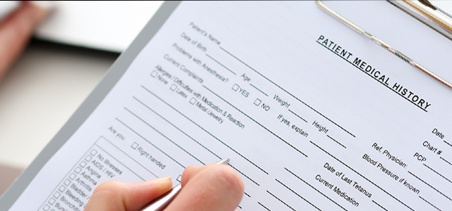 Female doctor hold clipboard pad filling out a Patient medical history form